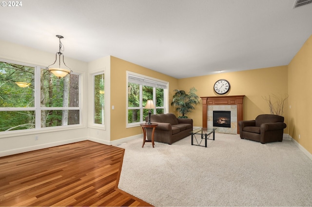 living room with light hardwood / wood-style flooring and a tiled fireplace