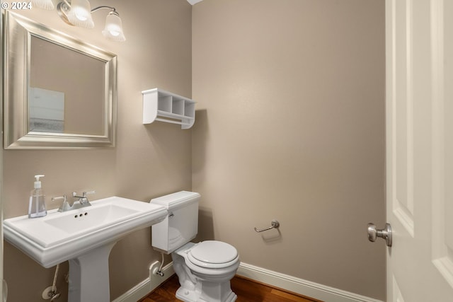 bathroom with hardwood / wood-style floors, toilet, and sink