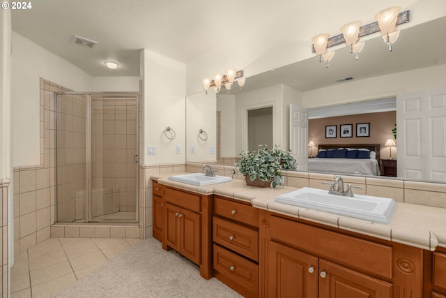 bathroom with tile patterned floors, vanity, and a shower with door