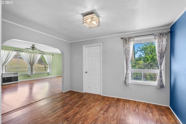 880 Heppner Spray Hwy, Heppner, OR 97836 - empty room featuring healthy amount of natural light, wood finished floors, arched walkways, and crown molding