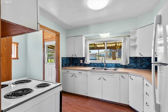 880 Heppner Spray Hwy, Heppner, OR 97836 - kitchen featuring a sink, white appliances, light countertops, tasteful backsplash, and white cabinetry
