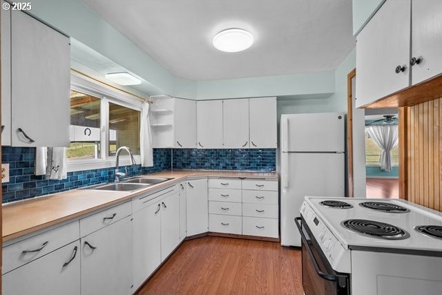 880 Heppner Spray Hwy, Heppner, OR 97836 - kitchen with white appliances, a sink, light wood-style flooring, tasteful backsplash, and white cabinetry