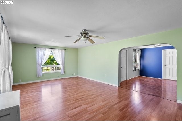 880 Heppner Spray Hwy, Heppner, OR 97836 - unfurnished living room with arched walkways, ceiling fan, wood finished floors, and baseboards