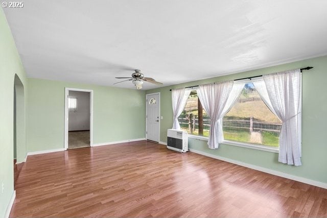 880 Heppner Spray Hwy, Heppner, OR 97836 - unfurnished living room with wood finished floors, ceiling fan, arched walkways, and baseboards