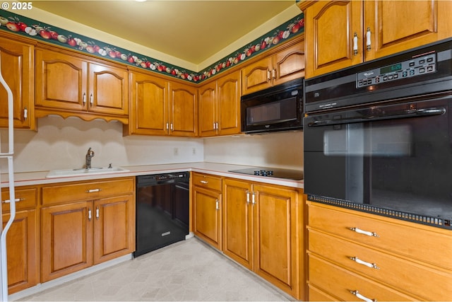 kitchen with black appliances, a sink, brown cabinets, and light countertops