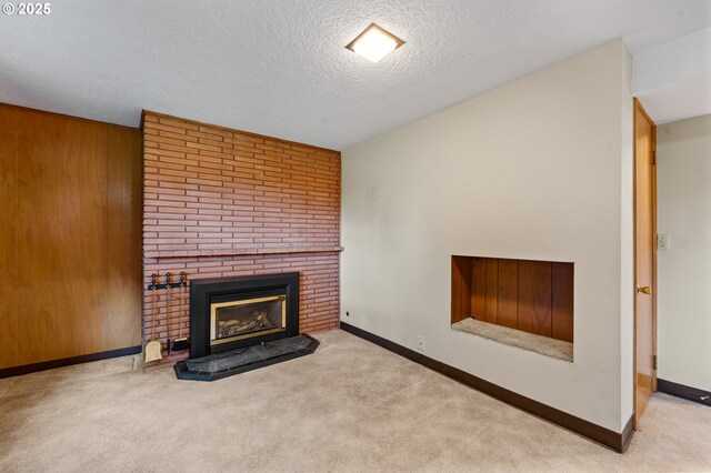unfurnished living room featuring carpet, a brick fireplace, baseboards, and a textured ceiling