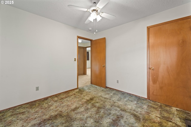 unfurnished bedroom featuring carpet floors, baseboards, a ceiling fan, and a textured ceiling