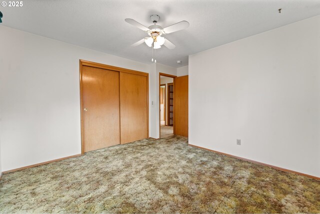 unfurnished bedroom with carpet, a closet, baseboards, and ceiling fan