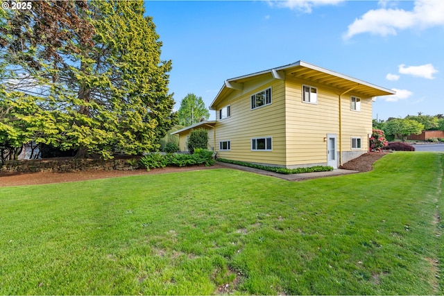 view of side of home with a yard