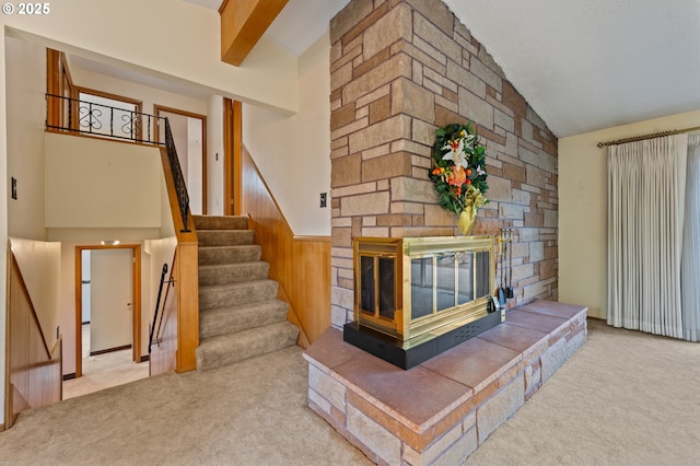 unfurnished living room with carpet, stairway, a fireplace, and vaulted ceiling