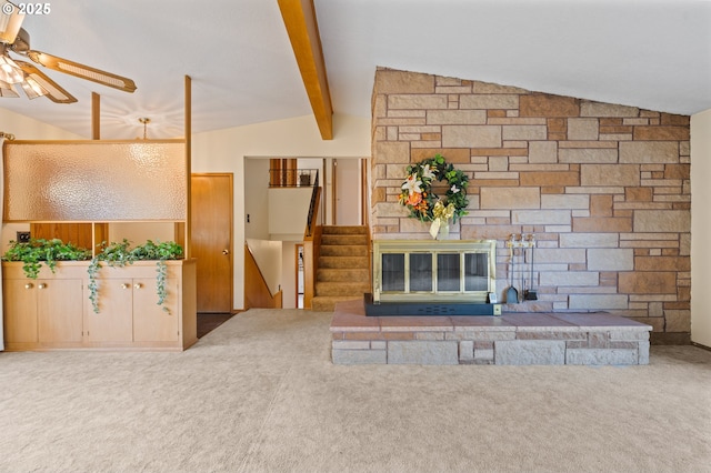 unfurnished living room with ceiling fan, carpet flooring, stairway, and a stone fireplace
