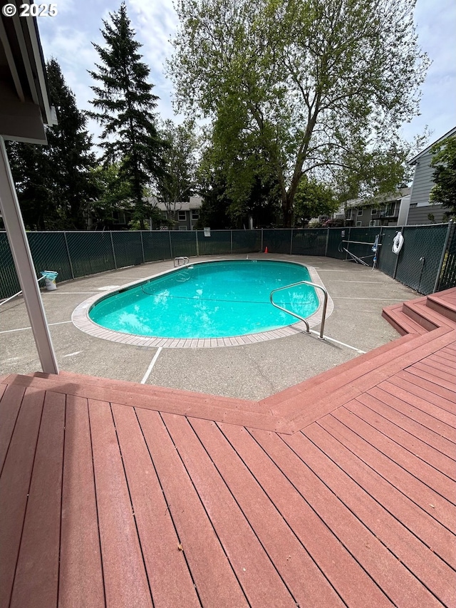 community pool with a deck and fence