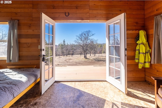 doorway to outside with wood walls and french doors