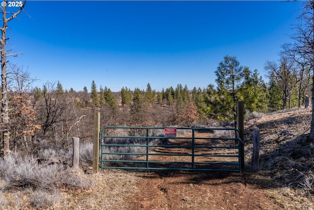 view of gate with a view of trees