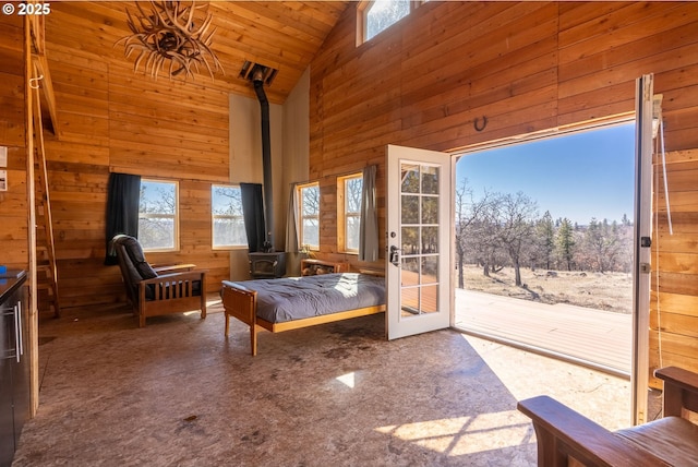 76 Big Springs Rd, Goldendale, WA 98620 - unfurnished bedroom featuring wooden walls, multiple windows, a wood stove, and access to outside