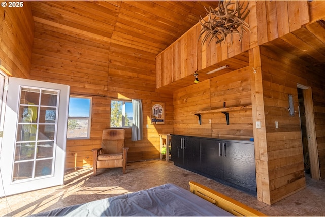 unfurnished bedroom featuring a towering ceiling and wooden walls