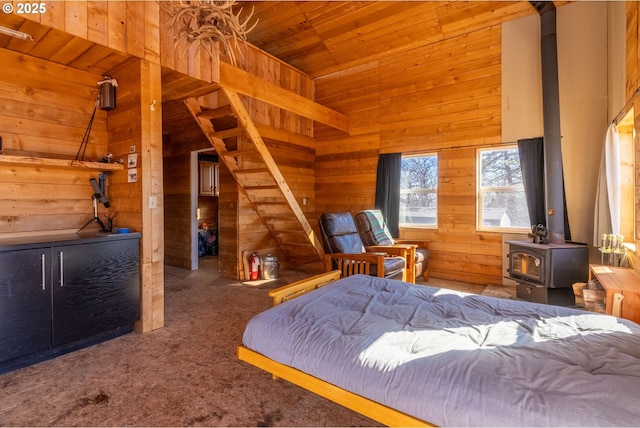 bedroom featuring carpet, lofted ceiling, a wood stove, wood walls, and wooden ceiling