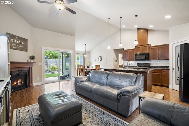 2085 Equestrian Loop S, Salem, OR 97302 - living room with high vaulted ceiling, light wood finished floors, a ceiling fan, a fireplace, and recessed lighting
