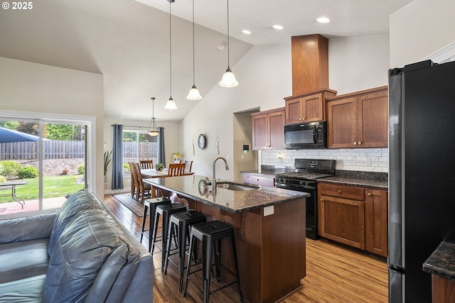 2085 Equestrian Loop S, Salem, OR 97302 - kitchen with black appliances, open floor plan, a kitchen bar, light wood-style flooring, and pendant lighting