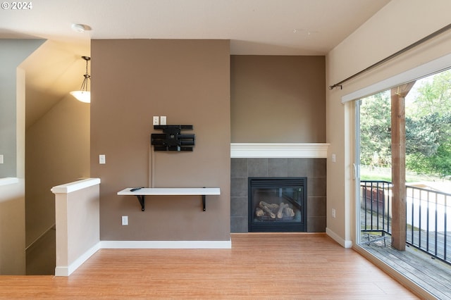 10450 SW Akilean Ter Unit 45, Portland, OR 97223 - unfurnished living room with wood finished floors, a tiled fireplace, and baseboards