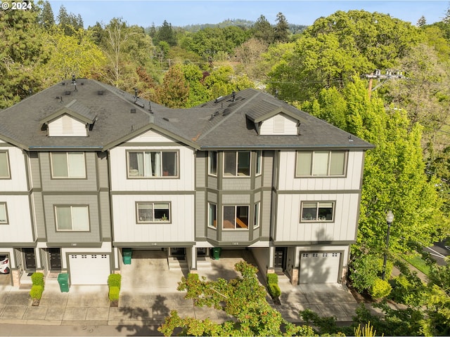 10450 SW Akilean Ter Unit 45, Portland, OR 97223 - view of front of home featuring a garage, a shingled roof, driveway, and a wooded view