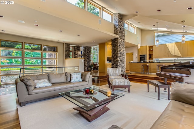 17907 SW Cicero Ct, Beaverton, OR 97007 - living room with a towering ceiling, recessed lighting, wood finished floors, and decorative columns