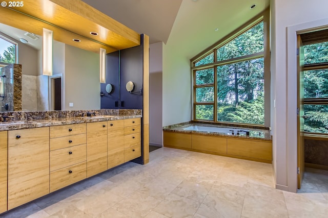 17907 SW Cicero Ct, Beaverton, OR 97007 - bathroom featuring double vanity, healthy amount of natural light, a bath, and vaulted ceiling