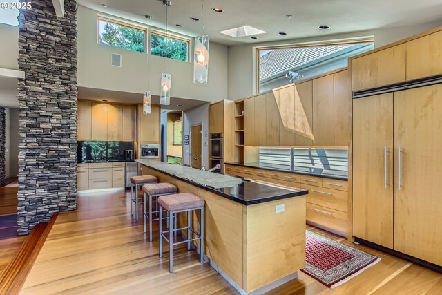 17907 SW Cicero Ct, Beaverton, OR 97007 - kitchen with paneled fridge, a high ceiling, double oven, a kitchen breakfast bar, and a kitchen island