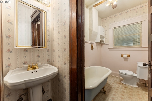 406 8th St, Springfield, OR 97477 - full bathroom featuring a freestanding tub, baseboards, toilet, tile patterned flooring, and wallpapered walls