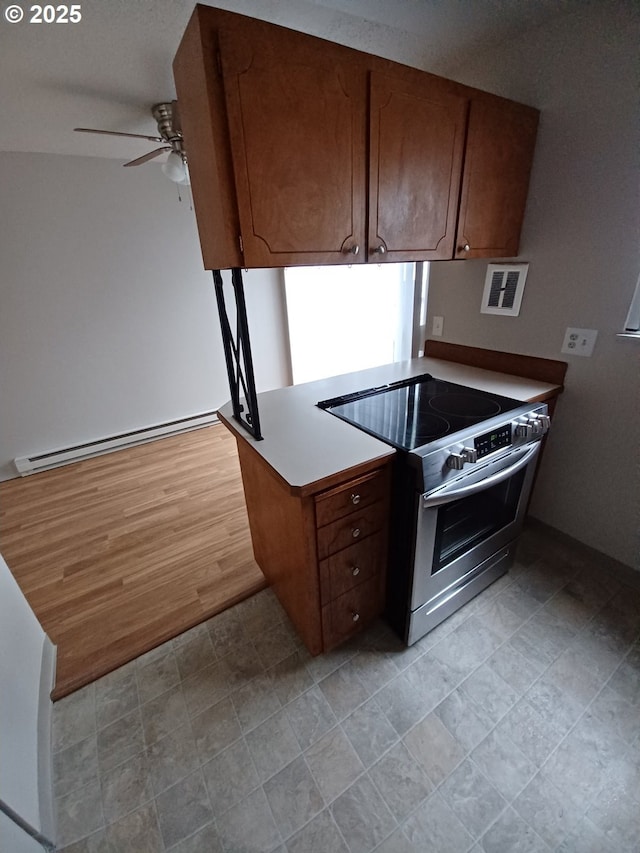 7720 SW Bel Aire Dr, Beaverton, OR 97008 - kitchen featuring stainless steel range with electric stovetop, ceiling fan, baseboard heating, a peninsula, and brown cabinets