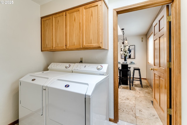 laundry area with baseboards, cabinet space, and independent washer and dryer