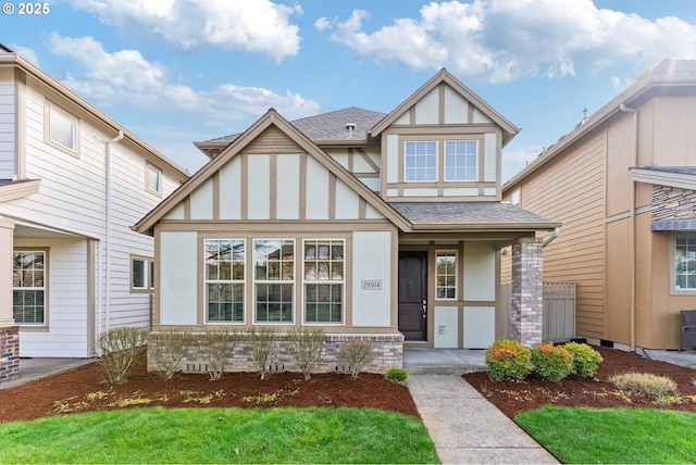 english style home featuring stucco siding and roof with shingles