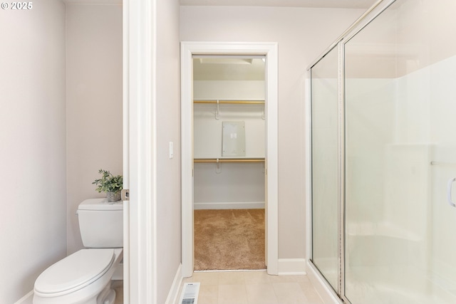 bathroom with a spacious closet, toilet, visible vents, and a stall shower