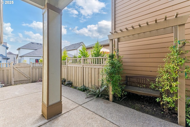 view of patio with a residential view, fence, and a gate