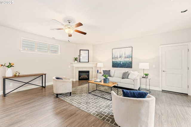 living room featuring a fireplace, wood finished floors, and baseboards