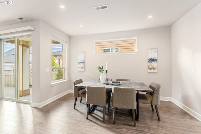 dining room featuring visible vents, baseboards, and wood finished floors