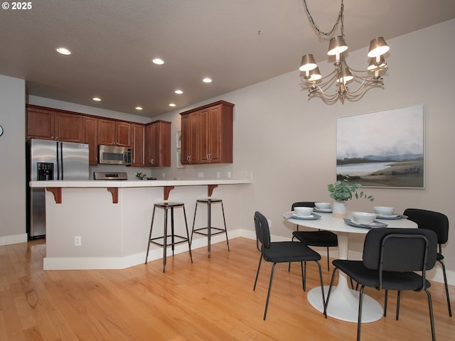 15320 SW Jasper Ln, Beaverton, OR 97007 - dining room with a chandelier, light wood-style floors, recessed lighting, and baseboards