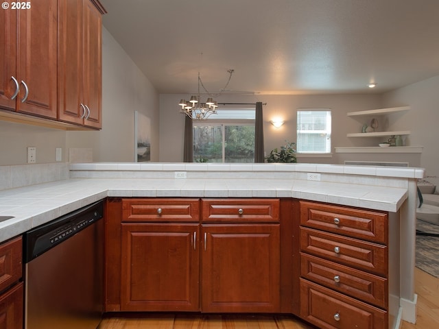 15320 SW Jasper Ln, Beaverton, OR 97007 - kitchen with stainless steel dishwasher, a chandelier, tile countertops, light wood-type flooring, and a peninsula