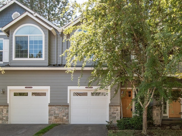 15320 SW Jasper Ln, Beaverton, OR 97007 - view of front of home with stone siding, a garage, and concrete driveway