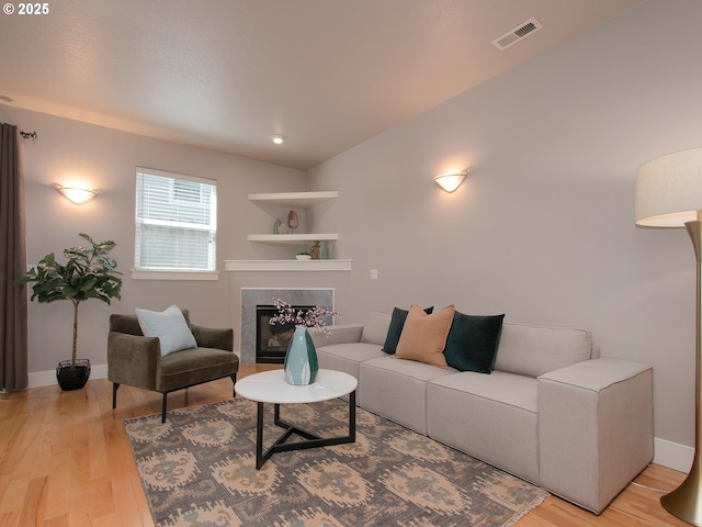 15320 SW Jasper Ln, Beaverton, OR 97007 - living area with light wood-type flooring, a glass covered fireplace, and baseboards