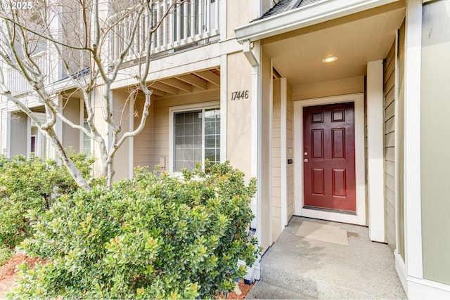 doorway to property featuring roof with shingles