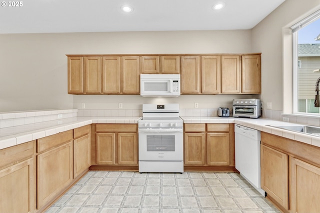 kitchen with recessed lighting, light floors, white appliances, and a sink