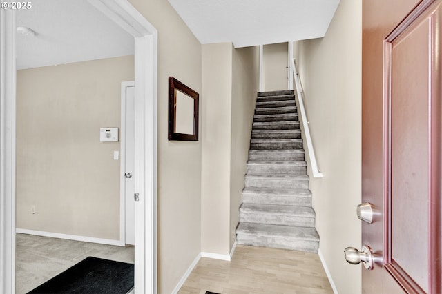 staircase with baseboards and wood finished floors