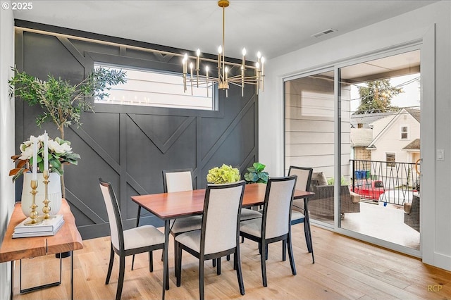 dining space featuring hardwood / wood-style flooring and a chandelier