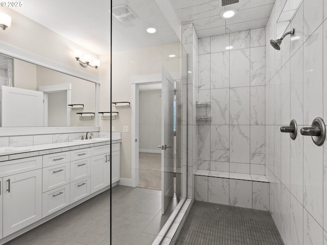 bathroom with vanity, tile patterned floors, and tiled shower