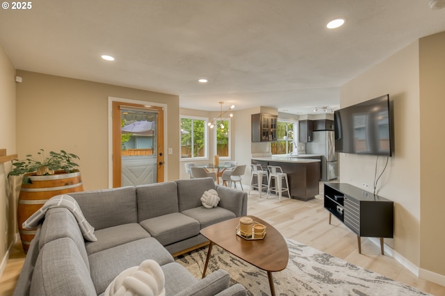 living area with recessed lighting, light wood-style floors, and baseboards