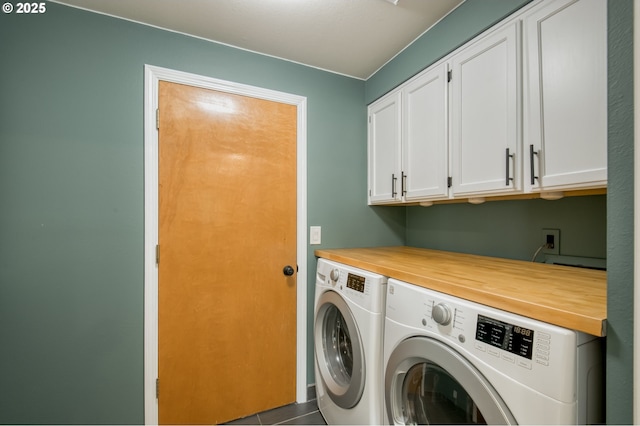 laundry area with separate washer and dryer, cabinet space, and dark tile patterned flooring