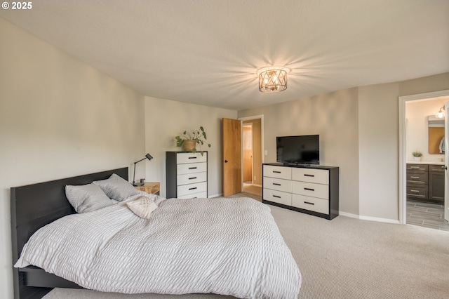bedroom with light colored carpet, baseboards, and connected bathroom