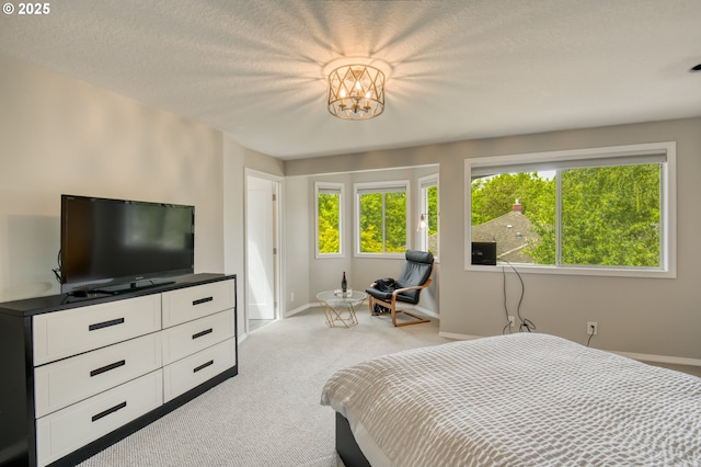 bedroom with light carpet, baseboards, and a chandelier