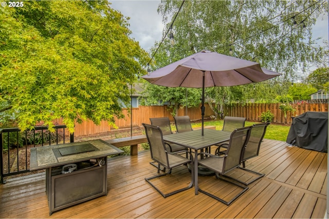 wooden deck with outdoor dining area, a fenced backyard, and a grill